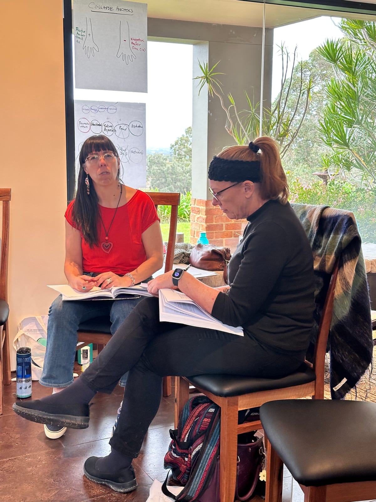 Two participants working through the training manual outdoors